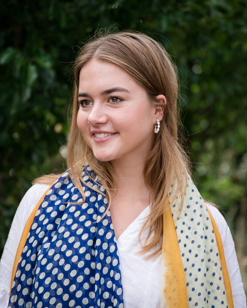 Elevate your style with our blue and off-white spot scarf, a versatile accessory that adds sophistication to any outfit. The abstract mustard border and playful tassels provide a pop of color and a finishing touch. The fresh and modern color combination makes it perfect for various outfits and occasions. Crafted from a comfortable polyester blend. Elevate your style with our blue and off-white spot scarf, a versatile accessory that adds sophistication to any outfit. The abstract mustard border and playful tassels provide a pop of color and a finishing touch. The fresh and modern color combination makes it perfect for various outfits and occasions. Crafted from a comfortable polyester blend.