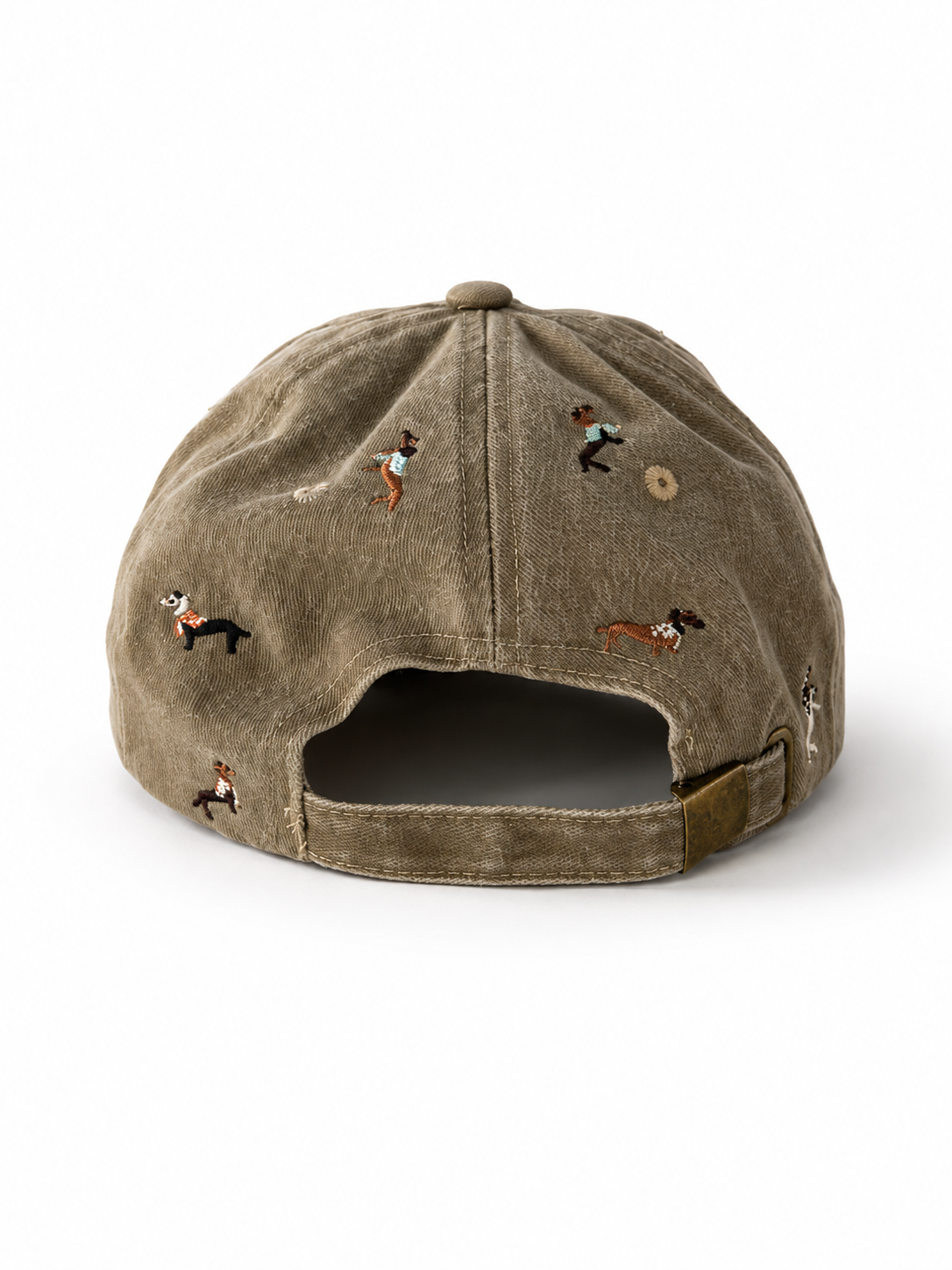 Back view of the beige dachshund-embroidered cap, showing the curved crown and the adjustable strap clipped into its brass buckle.