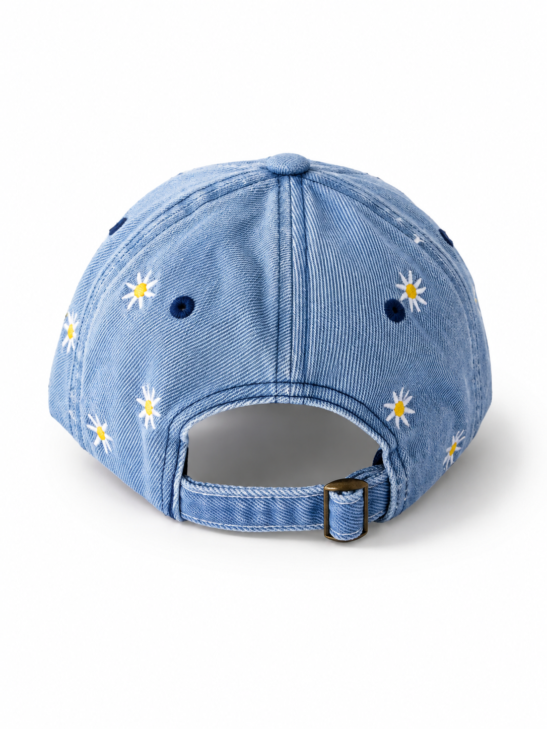 Back view of the mid-wash daisy-embroidered cap, showing the curved crown and the adjustable strap clipped into its brass buckle.
