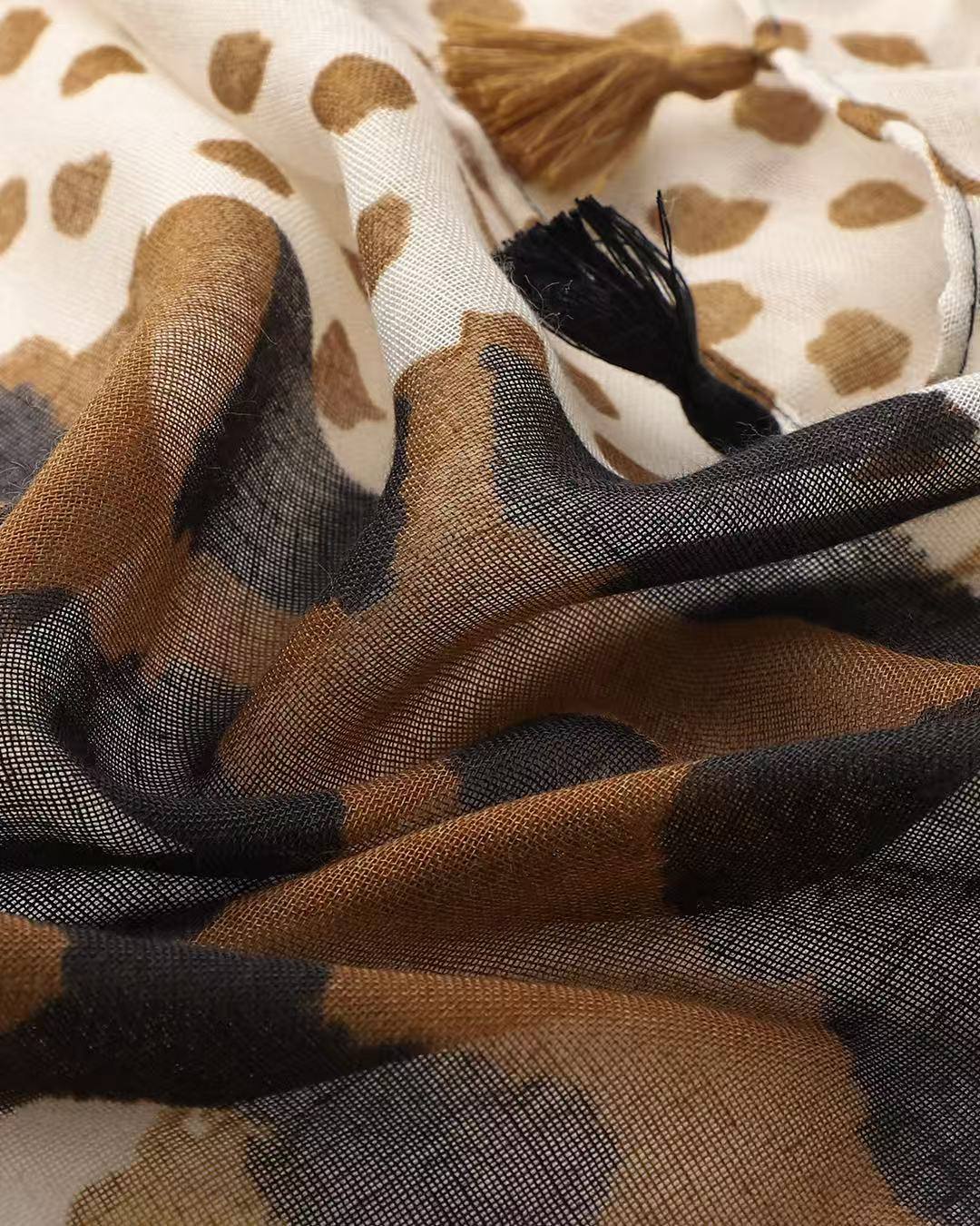 Close-up of leopard print scarf with black and tan tassels