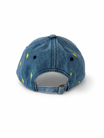 Mid-wash denim baseball cap embroidered with small yellow lemons, front view on a white background.