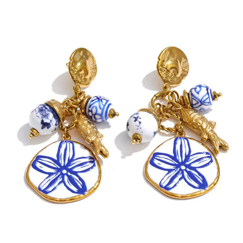 Gold disc stud earrings with blue and white porcelain beads, a gold fish charm and a white disc painted with a blue flower
