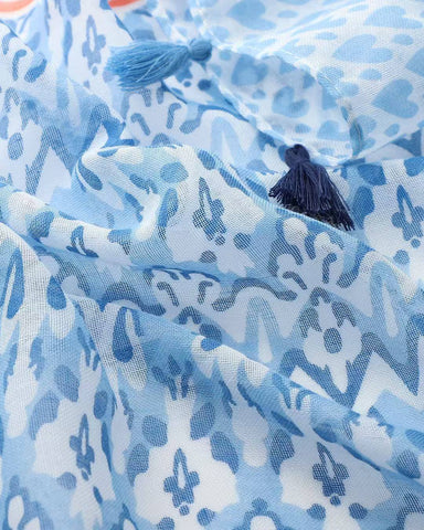 Close-up of blue ikat and heart print scarf with navy tassels