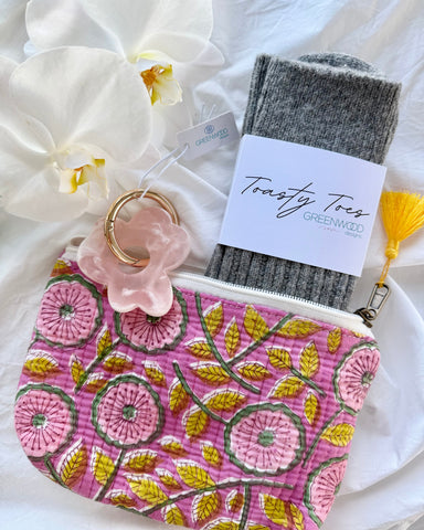 Floral pouch with gray socks and a tag on a white background