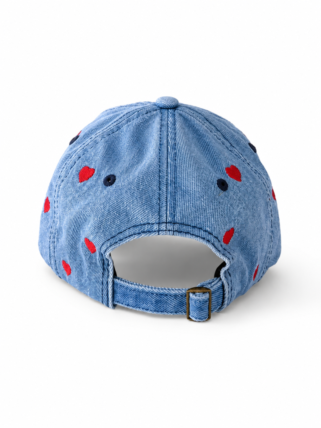 Back view of the mid-wash heart-embroidered cap, showing the curved crown and the adjustable strap clipped into its brass buckle.