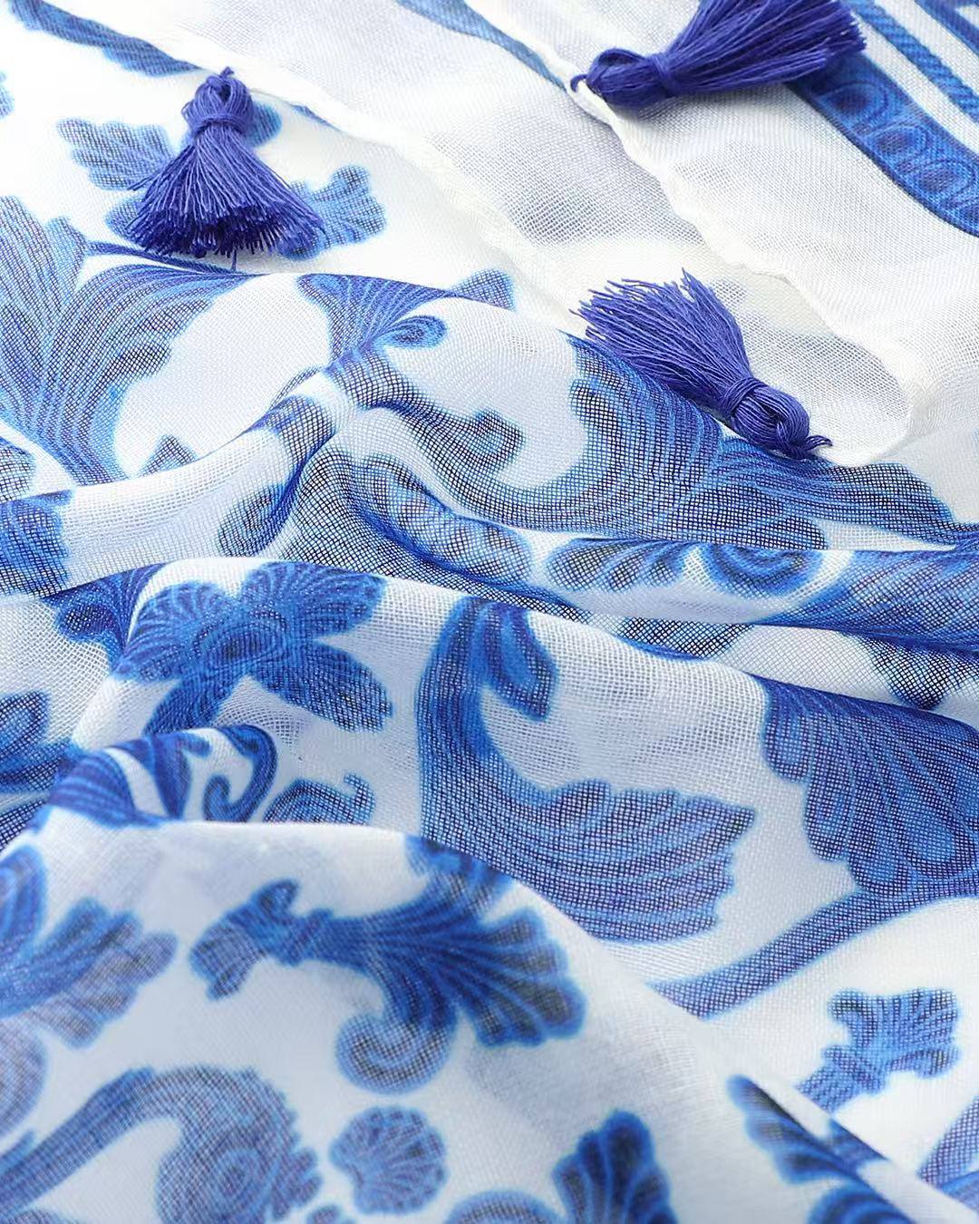 Close-up of blue and white damask print scarf with navy tassels