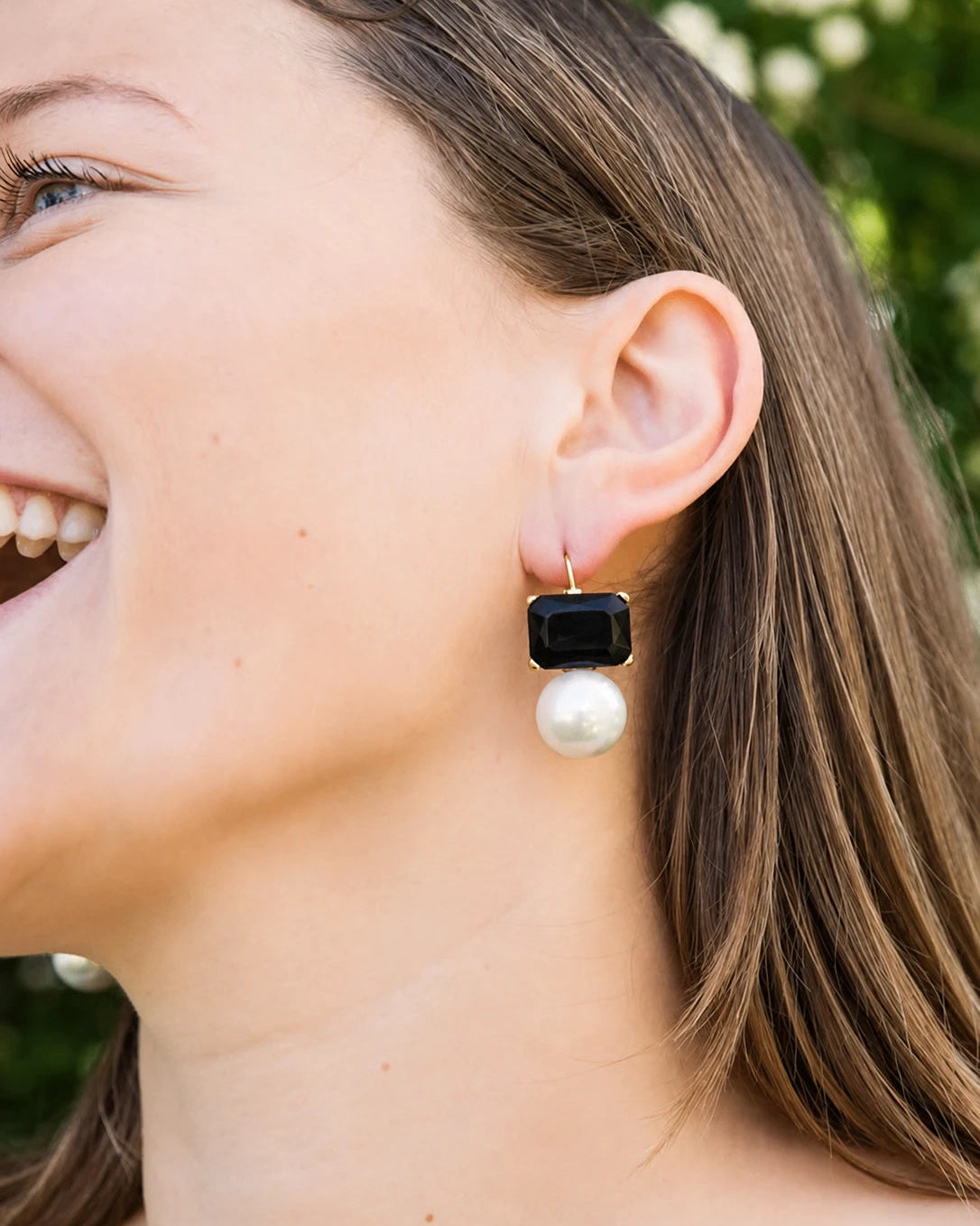 Woman wearing a black and pearl earring outdoors