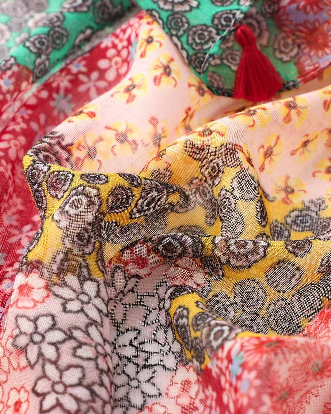 Close-up of red and pink bohemian patchwork print scarf with red tassel
