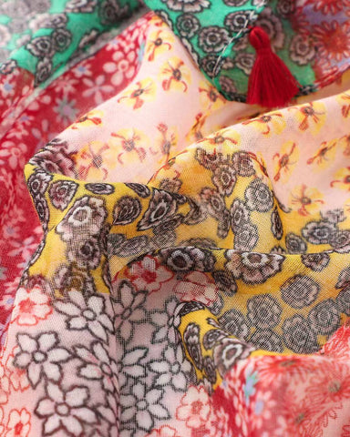 Close-up of red and pink bohemian patchwork print scarf with red tassel
