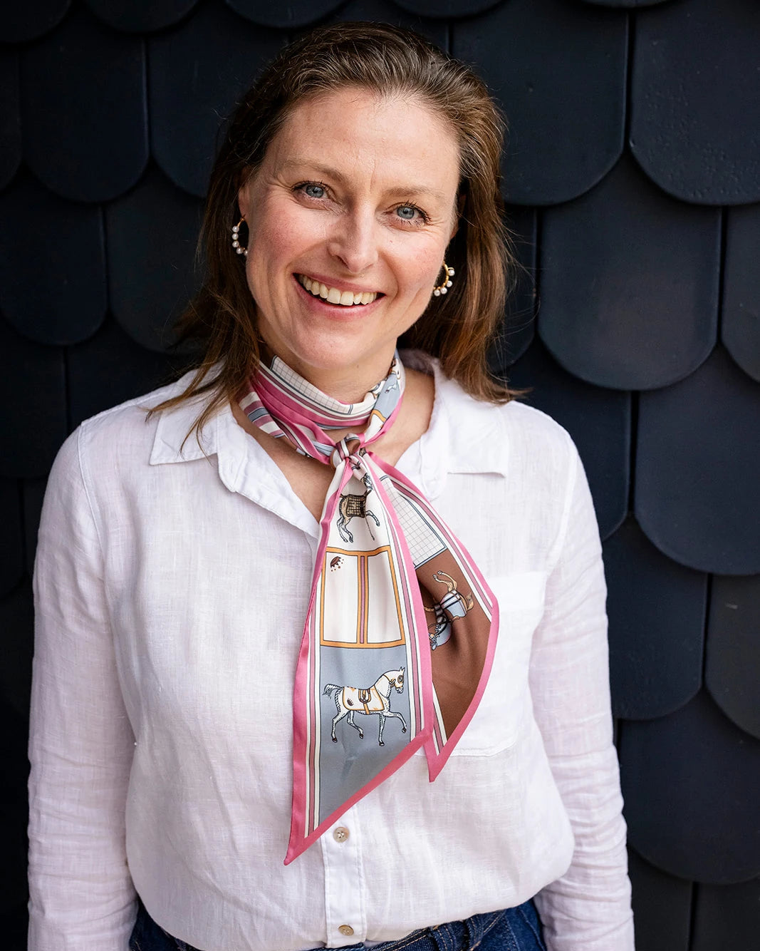 Satin neck scarf and bag tie in pink horse print styled around the neck