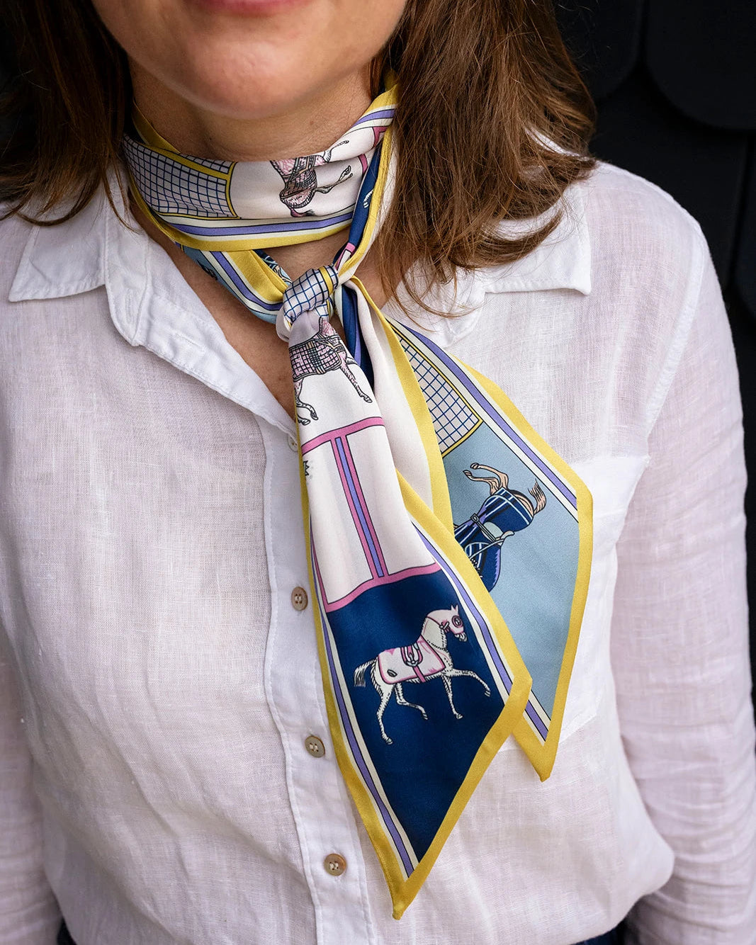 Satin neck scarf and bag tie in citrine yellow horse print styled around the neck