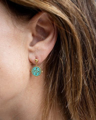 Gold stud earrings with an aqua enamel evil eye charm dangle