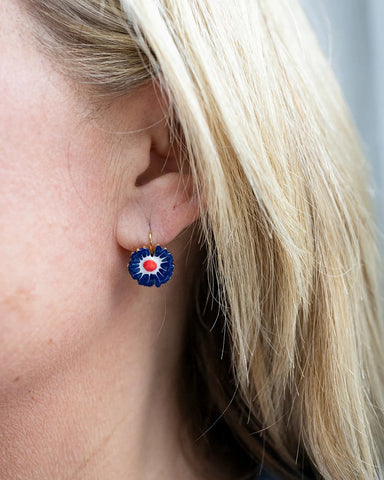 Gold hoop earrings with a navy enamel zinnia flower charm and red centre