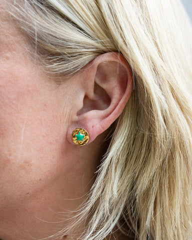 Gold stud earrings with a green enamel star at the centre