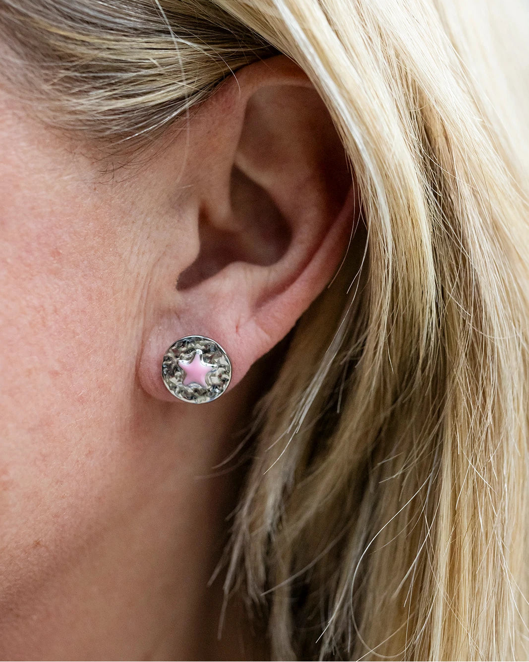 Silver stud earrings with a pink enamel star at the centre