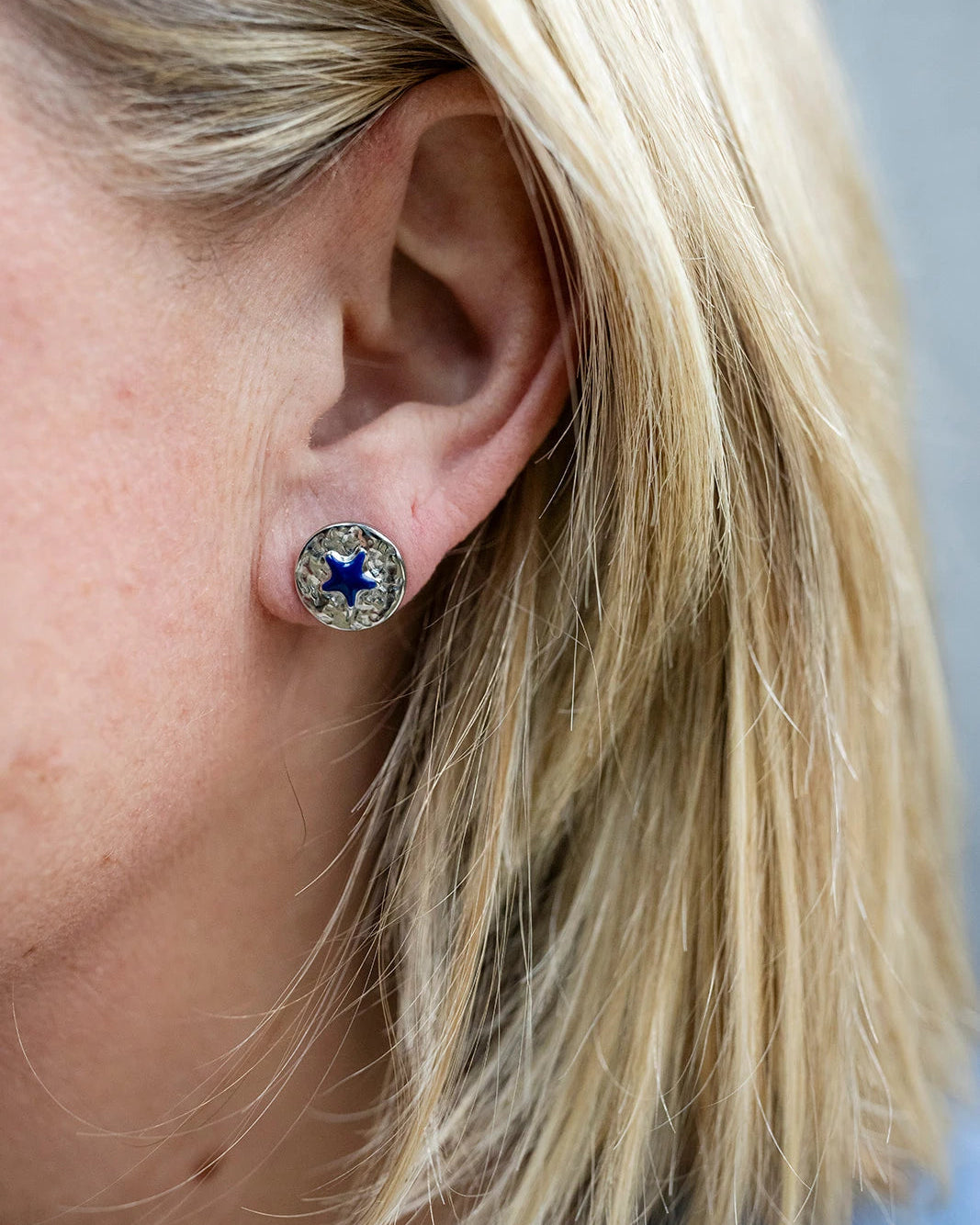 Silver stud earrings with a navy enamel star at the centre