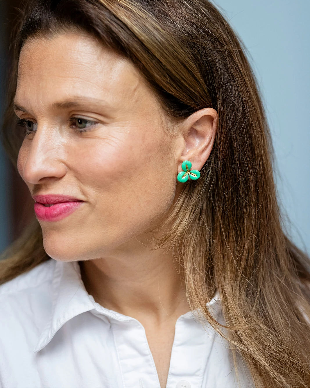 Gold stud earrings with a green enamel three-petal flower design