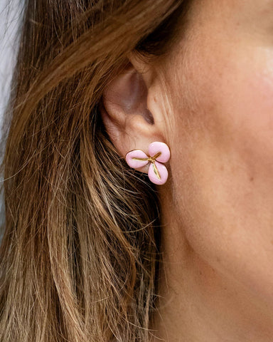 Gold stud earrings with a baby pink enamel three-petal flower design