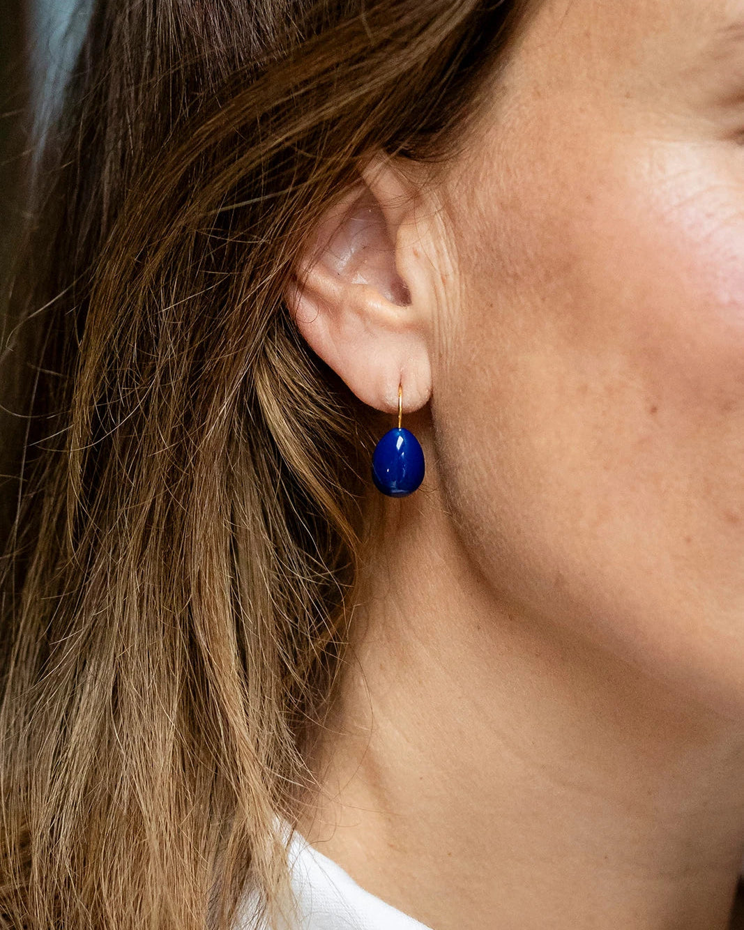 Gold drop earrings with a navy enamel teardrop design