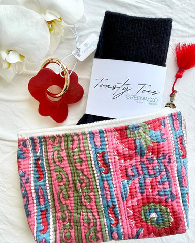 Colorful patterned pouch with a red keychain and black item on a white background
