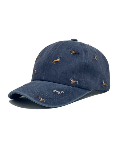 Navy denim baseball cap embroidered with colourful dachshund dogs, front view on a white background.