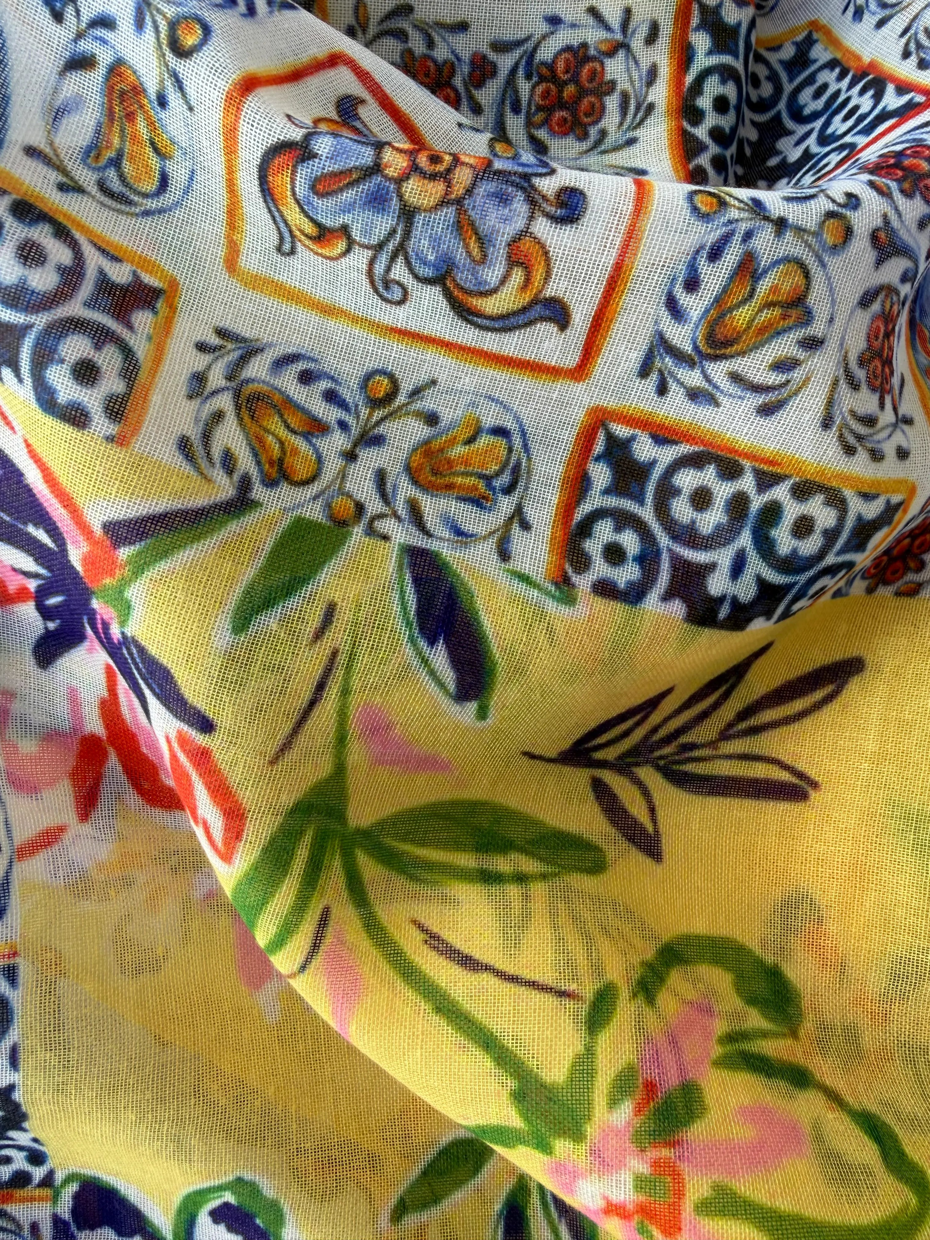 Lightweight scarf with a bright tropical floral and patterned print in yellow, blue, pink and green on white, finished with yellow tassels