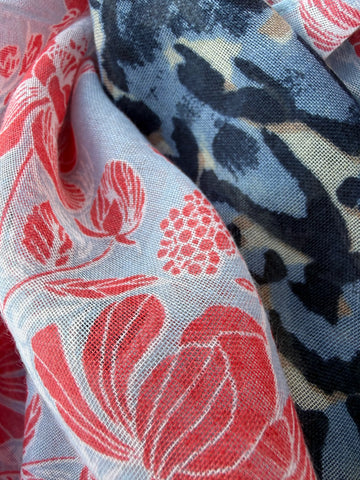 Lightweight scarf split into two prints, a navy and blue animal print on one half and a coral floral on soft blue on the other, with light blue and coral tassels