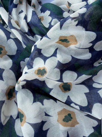 Lightweight navy scarf with large white and tan daisy-style flowers and green leaves, finished with navy and tan tassels