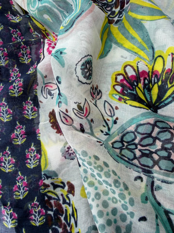 Lightweight scarf with an abstract floral print in bright pink, aqua, brown and yellow on white, framed by a navy floral border, with pink and navy tassels