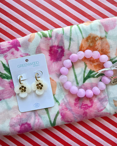 Close-up of the Coral floral scarf, the Light Pink Marble rock bracelet and Willa cream flower drop earrings with gold centres on a Greenwood Designs card.