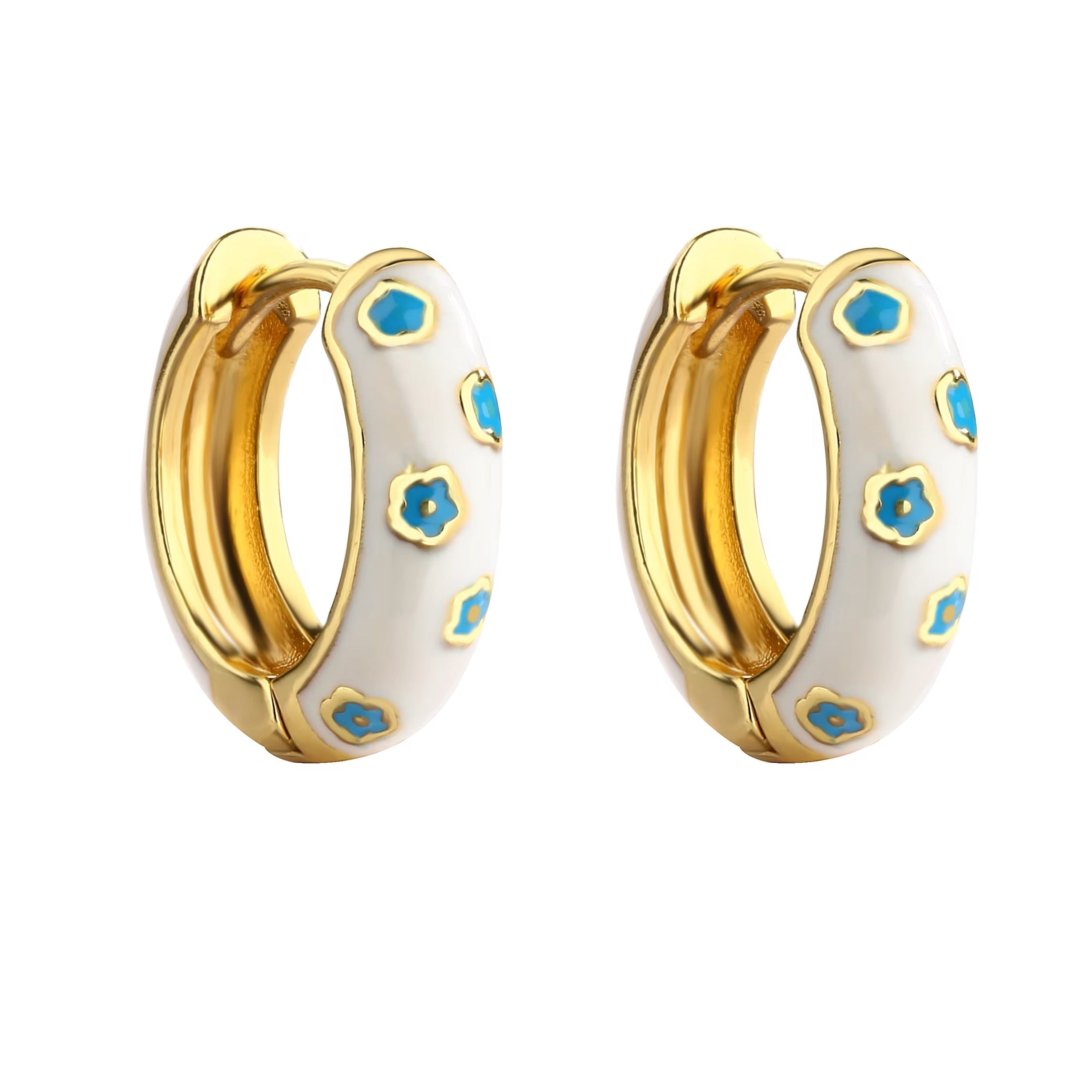 White and gold enamel hoop earrings with blue flower pattern on white background