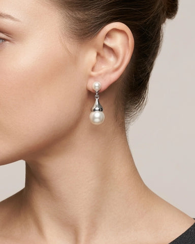 Woman wearing freshwater pearl drop earrings in sterling silver flower bud setting