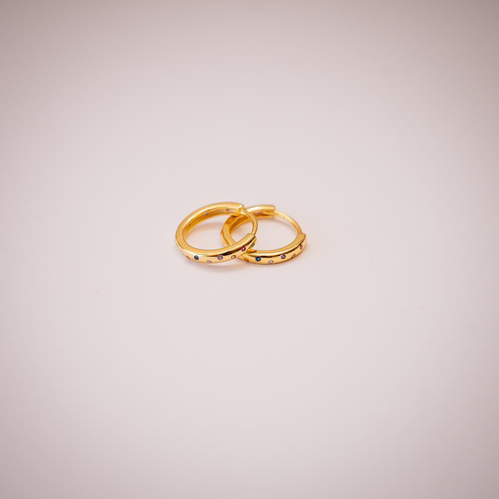 Gold hoop earrings with multi coloured crystals on white background