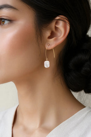 Woman wearing Maddie freshwater rectangular baroque pearl drop earrings in gold by Greenwood Designs, styled with a white top and hair up