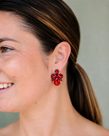 Woman smiling wearing Angel red crystal cluster stud earrings by Greenwood Designs, perfect for special occasions and evening styling