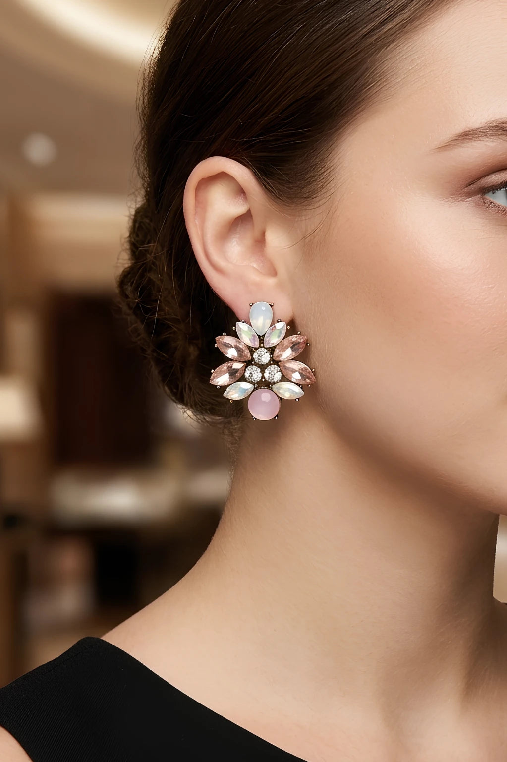 Woman wearing Peta soft pink crystal cluster stud earrings by Greenwood Designs, styled with a black top in an elegant indoor setting