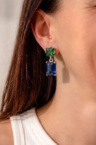 Pippa Emerald Green and Navy Blue Rectangle Crystal Dangle Earrings worn on model, featuring emerald green square crystal stud top and deep navy blue rectangle crystal drop in gold-plated setting, surgical steel posts, 4.5x1.8cm.