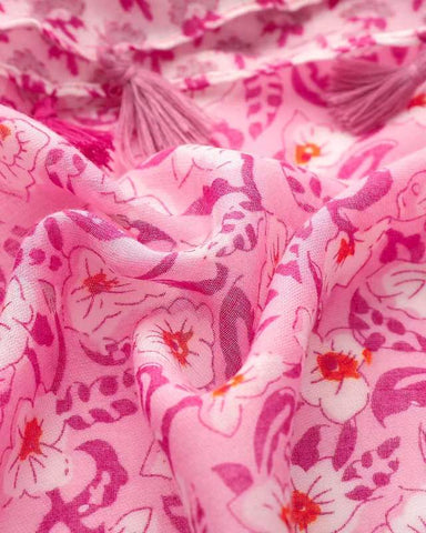 Close-up of pink and magenta floral print on lightweight scarf fabric with tassel