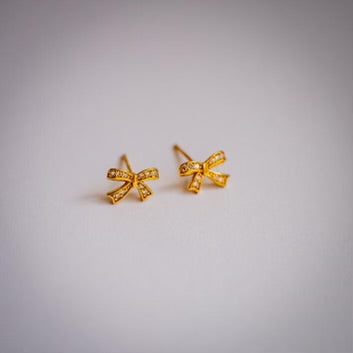 Gold plated crystal bow earrings on white background