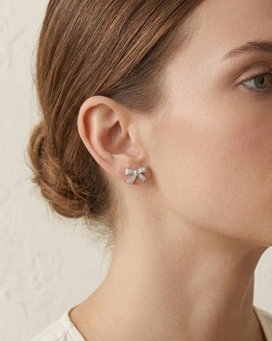 Woman wearing silver plated crystal bow earrings