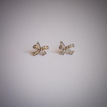 Silver plated crystal bow earrings on white background