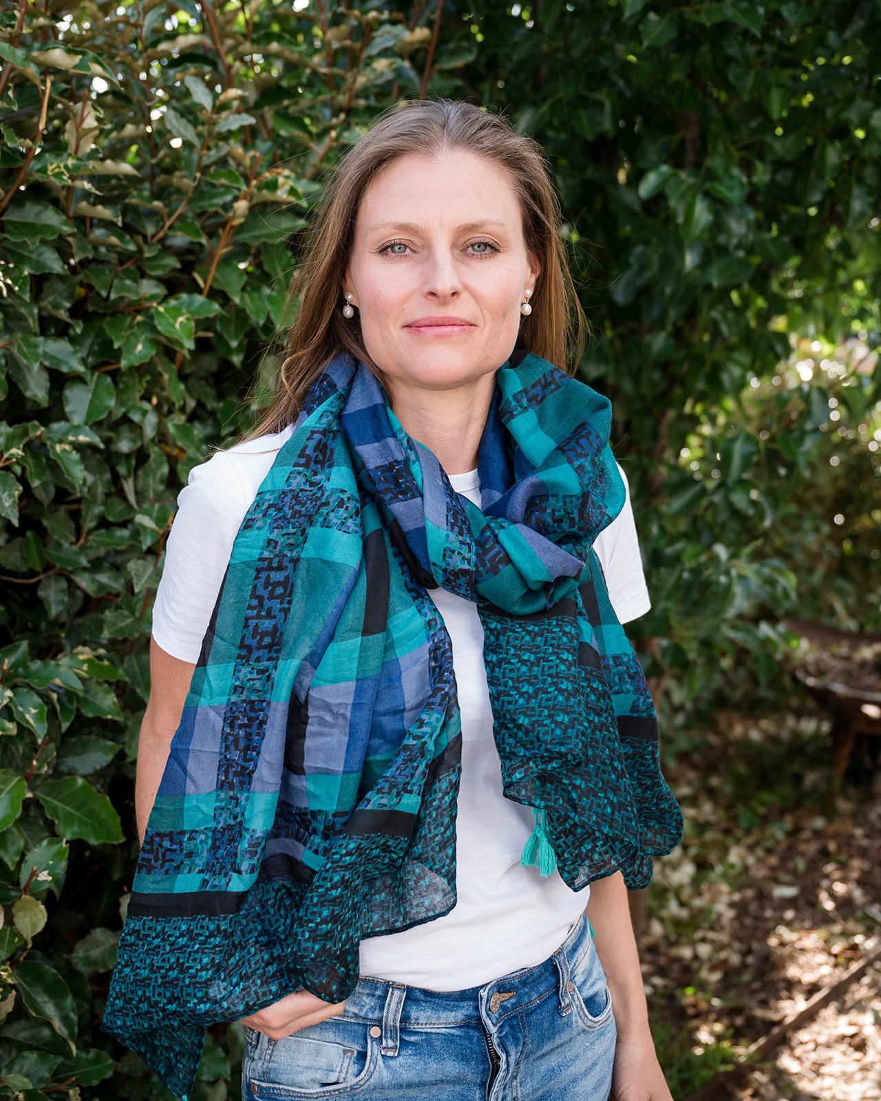 Elevate your look with our stylish tartan print scarf, showcasing a mix of blues and greens, highlighted by aqua tassels on each corner. The modern geometric design adds flair to this classic pattern, perfect for adding color and style to any outfit while staying cozy and chic. Crafted from a comfortable polyester blend.