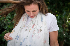Elevate your look with our soft white-based scarf, featuring a beautifully designed floral print in pastel pinks, blues, and yellows. White tassels at each corner complete the look, making this accessory a must-have for any wardrobe. The soft white base provides versatility, allowing easy pairing with a wide range of colours and styles.