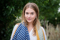 Elevate your style with our blue and off-white spot scarf, a versatile accessory that adds sophistication to any outfit. The abstract mustard border and playful tassels provide a pop of color and a finishing touch. The fresh and modern color combination makes it perfect for various outfits and occasions. Crafted from a comfortable polyester blend.