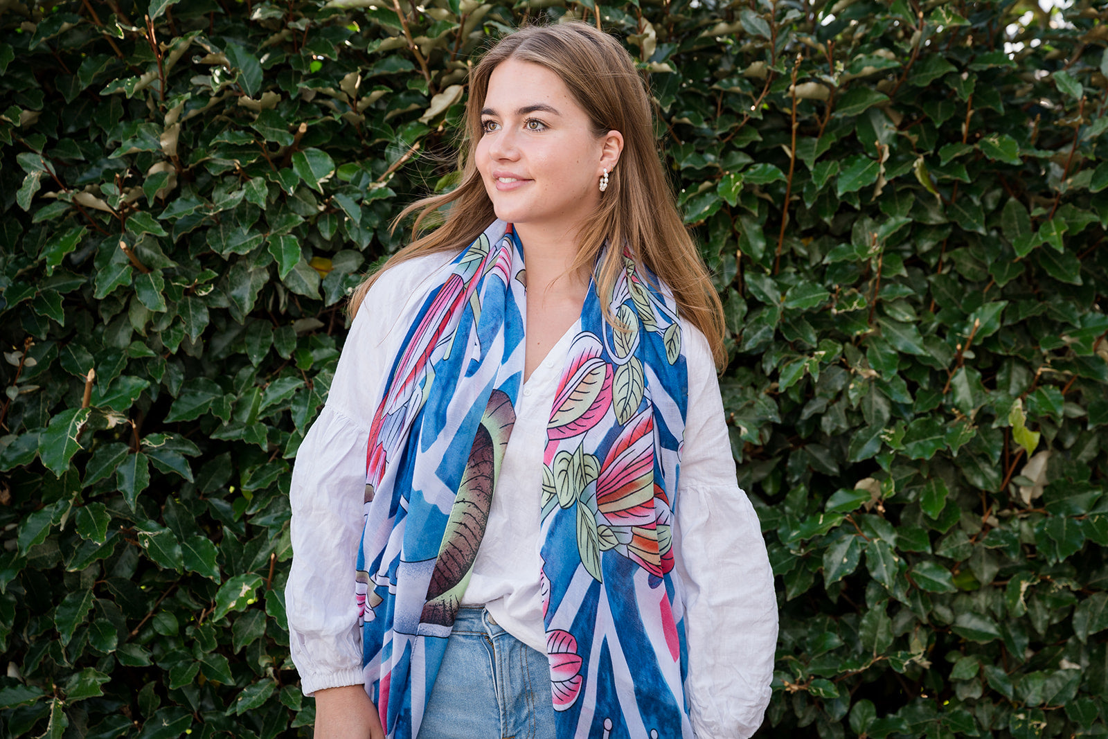 Transform your look with our botanic-inspired scarf, boasting a geometric blue background with bursts of red and green flowers. The elegant floral design against the crisp blue background is complemented by navy-blue tassels, adding sophistication and texture. Ideal for nature enthusiasts, this modern accessory is crafted from a comfortable polyester blend.